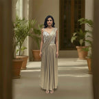 This glamorous outfit is in a rich metallic gold color. The blouse is covered in big, shiny mirror work that catches the light beautifully. It features a pre-draped saree style with neat pleats on the shoulder, making it very easy to wear without any hassle. The fabric is smooth and shiny. This outfit is bold, stylish, and perfect for cocktail parties and evening receptions.