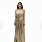 This glamorous outfit is in a rich metallic gold color. The balouse is covered in big, shiny mirror work that catches the light beautifully. It features a pre-draped saree style with neat pleats on the shoulder, making it very easy to wear without any hassle. The fabric is smooth and shiny. This outfit is bold, stylish, and perfect for cocktail parties and evening receptions.