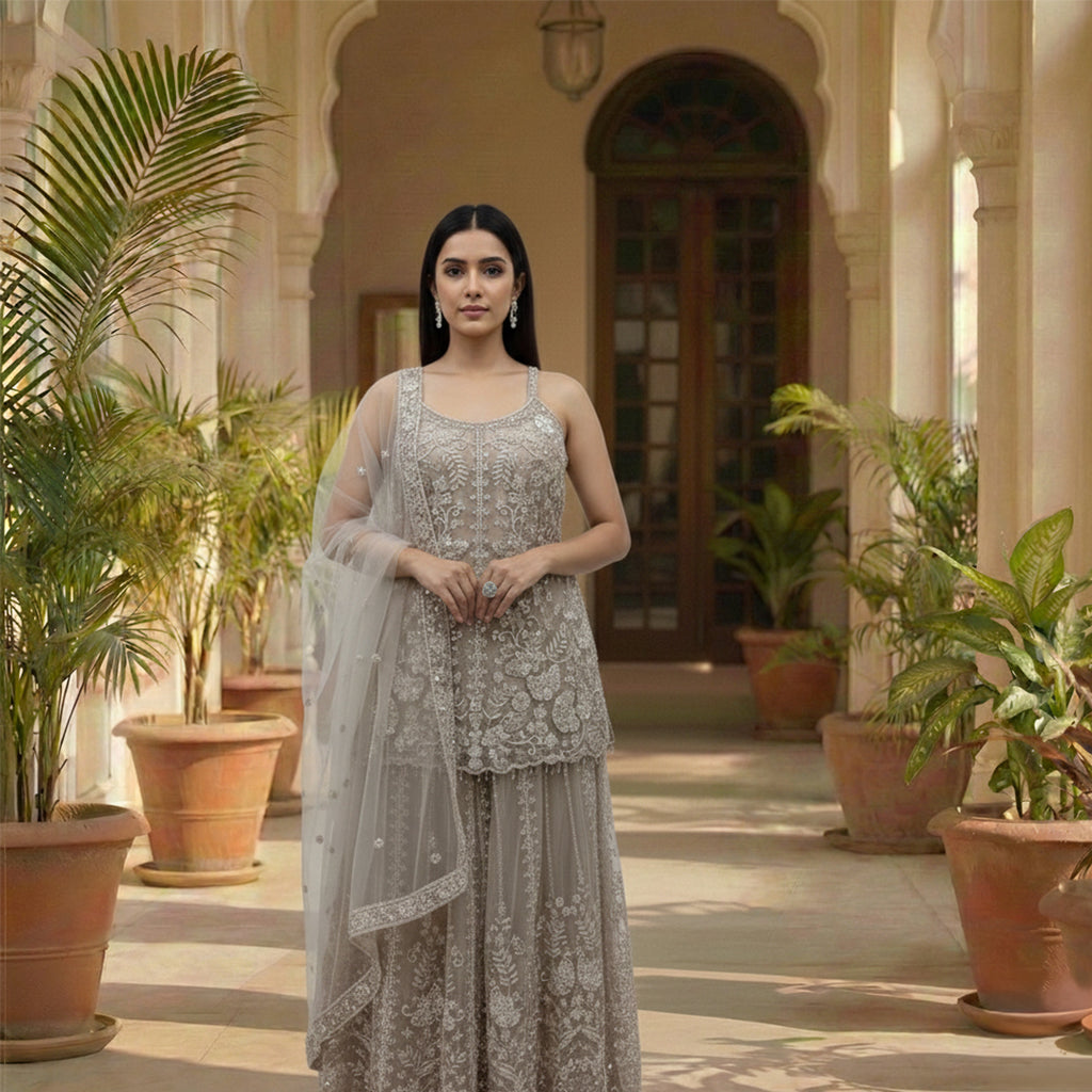 Radiate ethereal beauty in this Champagne Beige Net Sharara Set, featuring delicate 3D floral and tonal sequin embroidery. The soft, neutral palette and vine-like floral patterns create a dreamy, aesthetic that is perfect for an engagement or Nikah. Lightweight yet heavily detailed, this set offers a fairy-tale glow for your most special occasions.