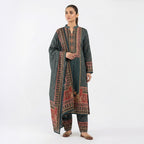 This traditional outfit is in a smart dark grey color. The kurta features a unique wavy line pattern all over and a detailed design on the neck in red and beige colors. It comes with matching pants and a beautiful shawl (dupatta) that has a rich, printed border. This outfit is elegant, comfortable, and perfect for office wear or casual winter days.
