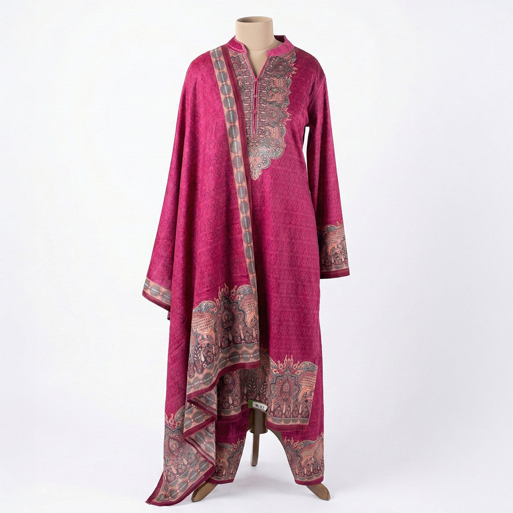 This stylish outfit is in a beautiful deep pink color. The long kurta has a nice pattern all over and a detailed traditional design around the neck. It features long sleeves and a lovely border at the bottom. It comes with matching pants and a warm shawl (dupatta) that has a pretty printed border. This outfit is cozy, elegant, and perfect for winter gatherings and daily wear.