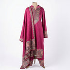 This stylish outfit is in a beautiful deep pink color. The long kurta has a nice pattern all over and a detailed traditional design around the neck. It features long sleeves and a lovely border at the bottom. It comes with matching pants and a warm shawl (dupatta) that has a pretty printed border. This outfit is cozy, elegant, and perfect for winter gatherings and daily wear.