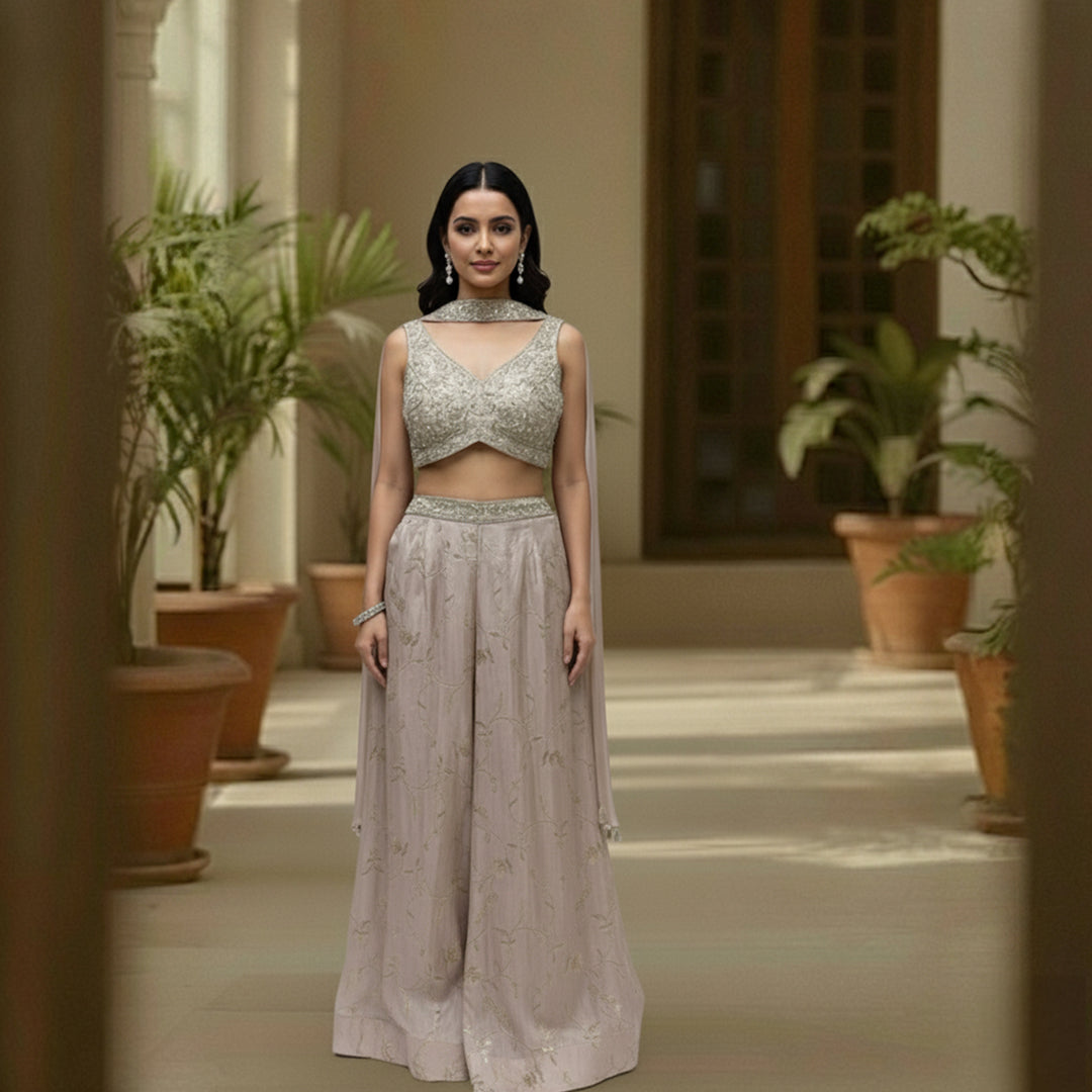 This stunning ivory embellished crop top and matching wide-leg palazzo pants set. This chic fusion wear ensemble perfectly balances modern style with traditional elegance.

The beautifully detailed crop top features intricate, shimmering embellishments, while the flowing, wide-leg pants provide a flattering and comfortable fit.

It’s the perfect choice for making a statement at any wedding function, from a lively sangeet night to an elegant engagement party, or for any festive event where you want to shine.