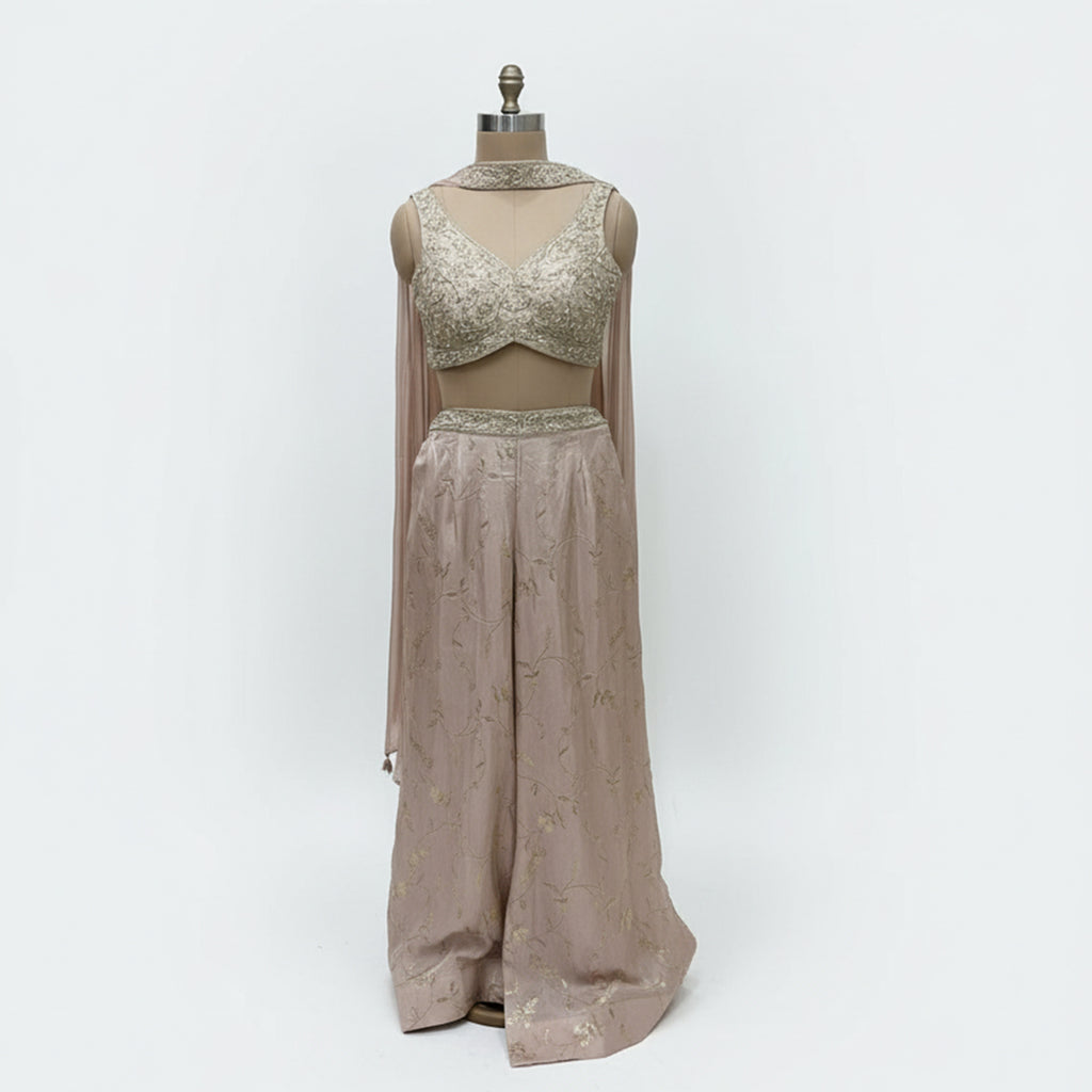 This stunning ivory embellished crop top and matching wide-leg palazzo pants set. This chic fusion wear ensemble perfectly balances modern style with traditional elegance.

The beautifully detailed crop top features intricate, shimmering embellishments, while the flowing, wide-leg pants provide a flattering and comfortable fit.

It’s the perfect choice for making a statement at any wedding function, from a lively sangeet night to an elegant engagement party, or for any festive event where you want to shine.
