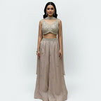 This stunning ivory embellished crop top and matching wide-leg palazzo pants set. This chic fusion wear ensemble perfectly balances modern style with traditional elegance.

The beautifully detailed crop top features intricate, shimmering embellishments, while the flowing, wide-leg pants provide a flattering and comfortable fit.

It’s the perfect choice for making a statement at any wedding function, from a lively sangeet night to an elegant engagement party, or for any festive event where you want to shine.