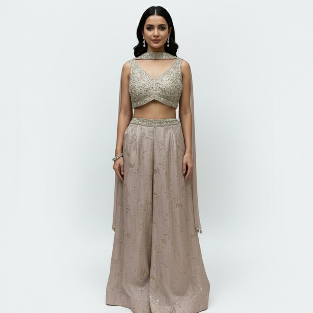 This stunning ivory embellished crop top and matching wide-leg palazzo pants set. This chic fusion wear ensemble perfectly balances modern style with traditional elegance.

The beautifully detailed crop top features intricate, shimmering embellishments, while the flowing, wide-leg pants provide a flattering and comfortable fit.

It’s the perfect choice for making a statement at any wedding function, from a lively sangeet night to an elegant engagement party, or for any festive event where you want to shine.