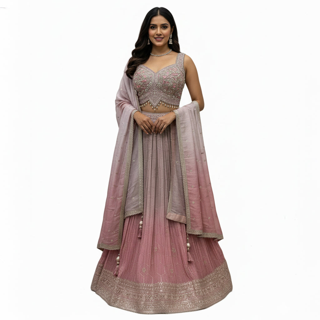 This pretty lehenga comes in soft shades of mauve and pink. The blouse is heavily decorated with silver and pink embroidery for a rich look.

The skirt has a unique crushed texture and a lovely color that fades from light purple to pink at the bottom.

It includes a matching dupatta with small sparkles. This outfit is elegant, dreamy, and perfect for engagement parties and day weddings.