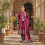 This stylish outfit is in a beautiful deep pink color. The long kurta has a nice pattern all over and a detailed traditional design around the neck. It features long sleeves and a lovely border at the bottom. It comes with matching pants and a warm shawl (dupatta) that has a pretty printed border. This outfit is cozy, elegant, and perfect for winter gatherings and daily wear.
