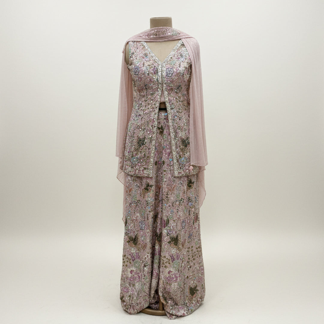 This exquisite outfit comes in a soft pastel pink color with beautiful floral embroidery all over. The top has a stylish front-open design and a flattering neckline that adds a modern touch.

The matching wide-leg pants flow gracefully, giving the outfit a comfortable yet classy look.


A light pink dupatta with a delicate texture completes the set, making it perfect for daytime events, parties or festive occasions where you want to look graceful and chic.