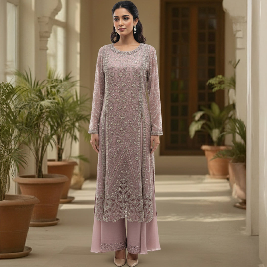 This elegant outfit is designed in a soft blush pink shade with delicate silver embroidery all over, giving it a graceful and classy look. The long kurta features detailed handwork with floral and geometric patterns that add a touch of sophistication.

The matching palazzo pants have a simple yet elegant border that complements the overall design beautifully.&nbsp;Perfect for weddings, receptions or festive occasions, this outfit combines subtle shine with timeless charm, making it ideal for an elegant and 