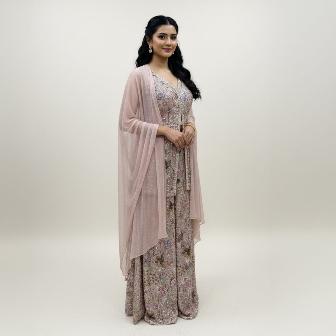 This exquisite outfit comes in a soft pastel pink color with beautiful floral embroidery all over. The top has a stylish front-open design and a flattering neckline that adds a modern touch.

The matching wide-leg pants flow gracefully, giving the outfit a comfortable yet classy look.


A light pink dupatta with a delicate texture completes the set, making it perfect for daytime events, parties or festive occasions where you want to look graceful and chic.