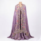 A lovely full-length outfit in a soft lavender shade. It has a flowy Palazzo paired with a beautifully embroidered cape featuring colorful floral work and shiny details.

The matching blouse also has the same embroidery. This outfit looks elegant and is perfect for weddings, parties, and festive occasions.