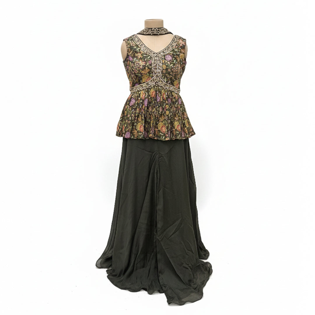 This stylish outfit features a short frock-style top with a beautiful floral print and detailed embroidery on the V-neckline. It is paired with a solid, dark-colored palazzo that is smooth and flowy. The set includes a matching dupatta, making it a trendy and elegant choice for parties.