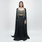 Modernize your ethnic style with this 3-piece Midnight Black Indo-Western Set. It features a hand-embroidered mirror-work bustier paired with a flowing silk skirt and a sheer, sequin-sprinkled georgette cape. This sleek, monochromatic look offers a sophisticated alternative to traditional wear, making it an ideal pick for cocktail nights and high-end receptions.