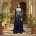 Modernize your ethnic style with this 3-piece Midnight Black Indo-Western Set. It features a hand-embroidered mirror-work bustier paired with a flowing silk skirt and a sheer, sequin-sprinkled georgette cape. This sleek, monochromatic look offers a sophisticated alternative to traditional wear, making it an ideal pick for cocktail nights and high-end receptions.