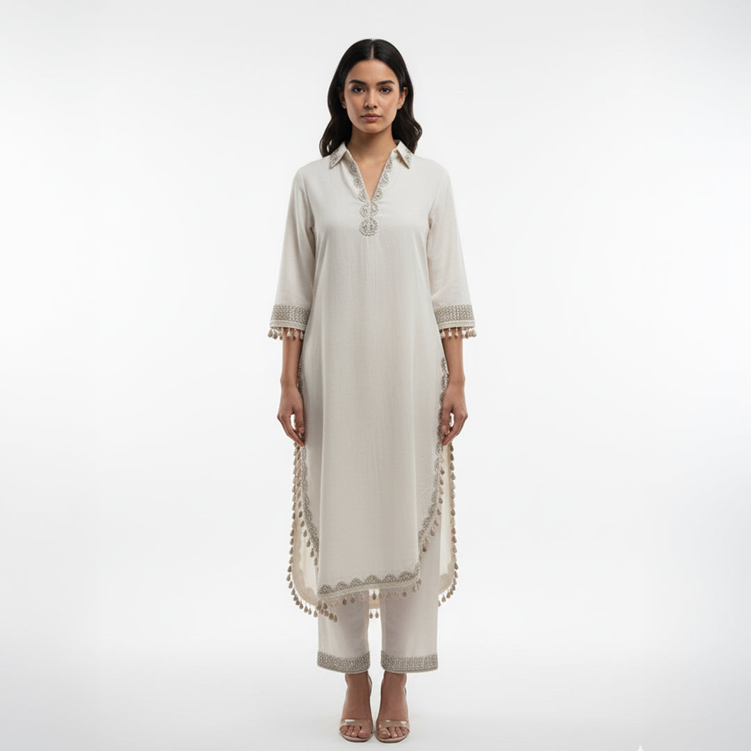 This simple and elegant outfit in a soft off-white color with delicate silver embroidery. The neckline, sleeves and borders are beautifully detailed with fine threadwork and tiny tassels that add a charming touch.

The straight cut and light fabric give it a graceful and comfortable look, perfect for both casual and semi-formal occasions.


Minimal yet classy, this outfit is ideal for daytime gatherings, festive lunches or when you want to look effortlessly stylish.