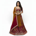This beautiful lehenga comes in a lovely mix of mustard yellow and deep pink colors. The blouse is in pink and fully decorated with gold patterns.

The skirt has a traditional look with gold lines and shades from yellow to pink at the bottom. It includes a matching shaded dupatta with a shiny gold border.

This outfit is bright, traditional, and perfect for Haldi ceremonies and weddings.