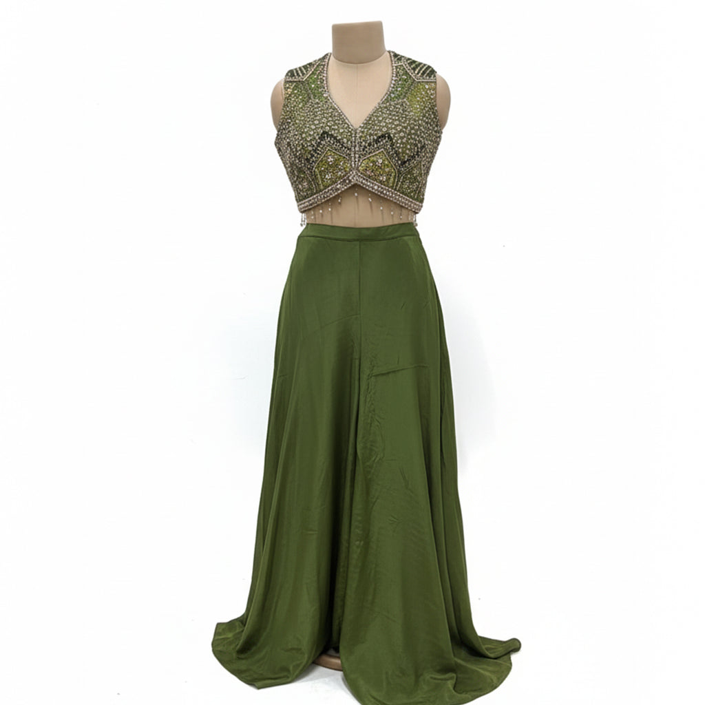 This contemporary ethnic outfit features a sleeveless V-neck crop top shimmering with intricate hand-embroidery, sequins, and beadwork.

It is perfectly paired with floor-length, wide-legged trousers in a coordinating shade of olive green.

The pants are designed with an elegant, draped silhouette, crafted from a lightweight, flowy material that moves beautifully. Perfect for parties, weddings, festive looks