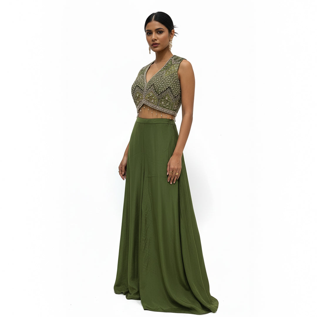 This contemporary ethnic outfit features a sleeveless V-neck crop top shimmering with intricate hand-embroidery, sequins, and beadwork.

It is perfectly paired with floor-length, wide-legged trousers in a coordinating shade of olive green.

The pants are designed with an elegant, draped silhouette, crafted from a lightweight, flowy material that moves beautifully. Perfect for parties, weddings, festive looks