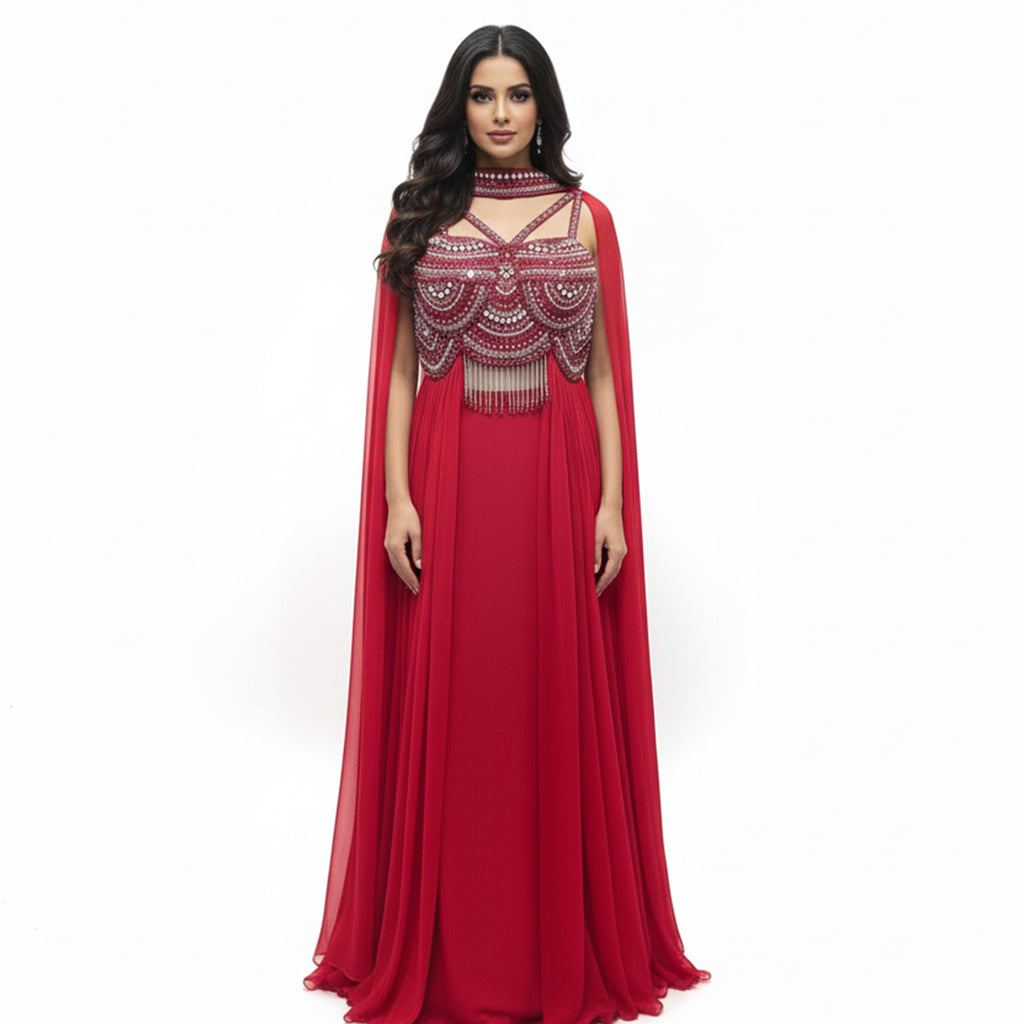 This dazzling outfit is in a beautiful red color. It features a stylish cut-out kurta that is heavily decorated with shiny silver beads and mirrors. It has a high-neck design and cute hanging tassels at the waist. It comes with flowy palazzo pants and a matching sheer dupatta. This outfit is bold, modern, and perfect for cocktail parties and evening events.