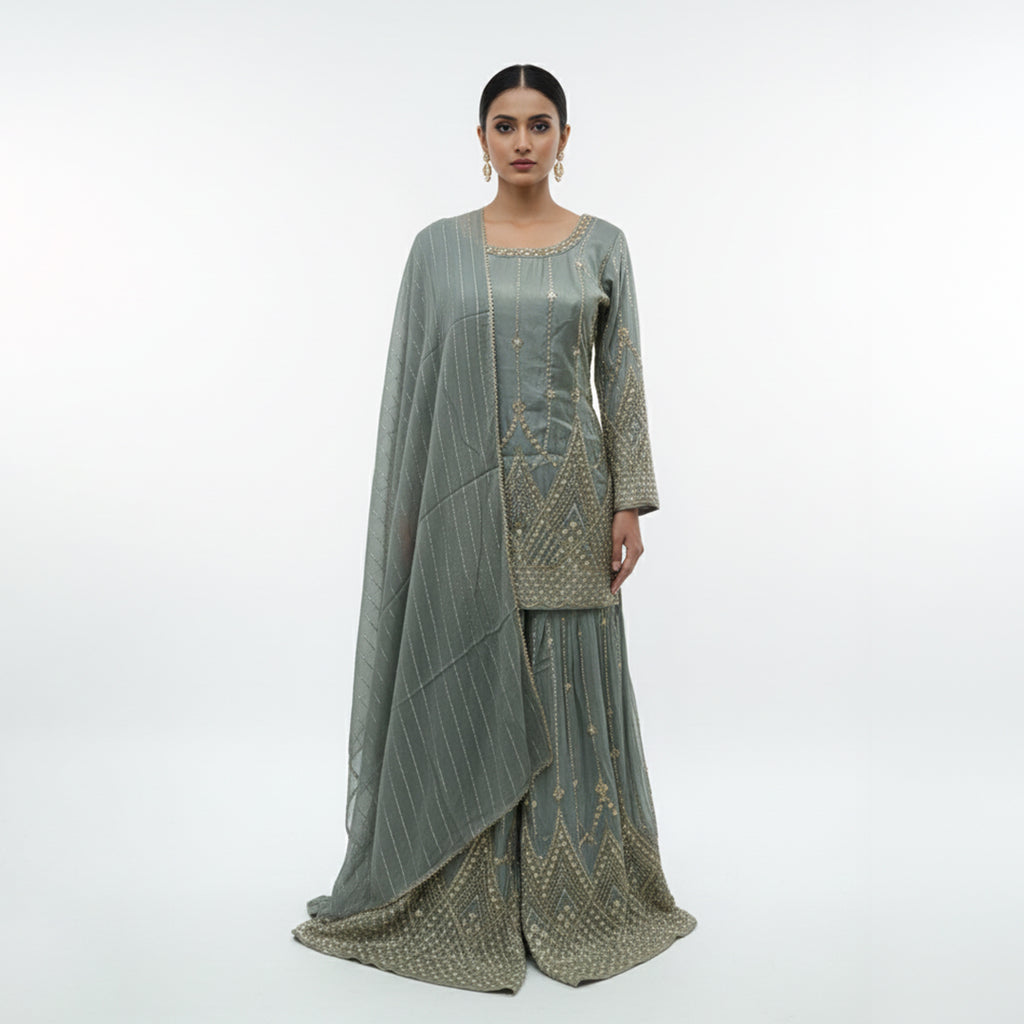 Green Georgette Sharara Set, featuring dazzling  sequin stripes that create a flattering, elongated silhouette. The heavily flared bottoms provide the volume of a lehenga with the comfort of a sharara. Finished with intricate scalloped borders and shimmering stonework, this ensemble is a high-impact choice for wedding receptions and evening galas.