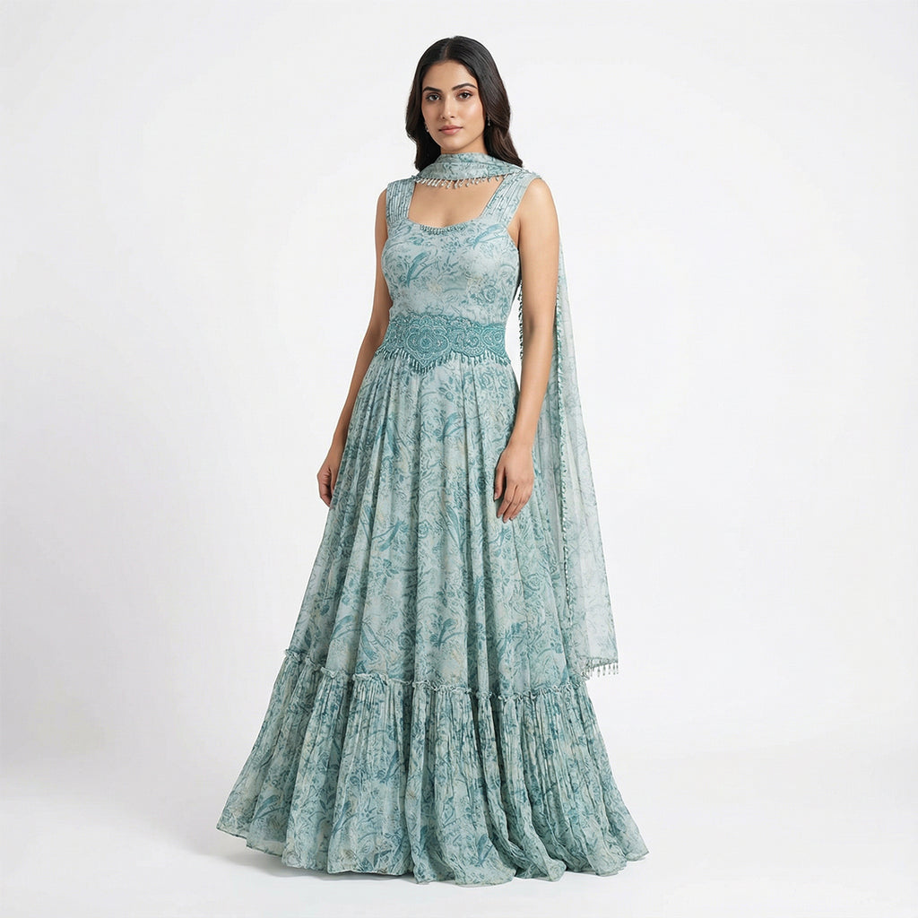 Embrace boho-luxe vibes with this Seafoam Green Georgette Maxi, featuring a bird and floral print. The tiered ruffle hem adds movement, while the hand-beaded turquoise waist belt and matching neckpiece provide a high-fashion edge. This lightweight, breathable gown is perfect for destination weddings, Mehendi parties, or any sun-drenched outdoor celebration
