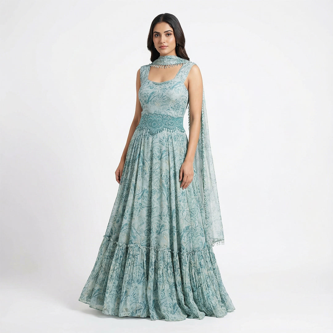Embrace boho-luxe vibes with this Seafoam Green Georgette Maxi, featuring a bird and floral print. The tiered ruffle hem adds movement, while the hand-beaded turquoise waist belt and matching neckpiece provide a high-fashion edge. This lightweight, breathable gown is perfect for destination weddings, Mehendi parties, or any sun-drenched outdoor celebration