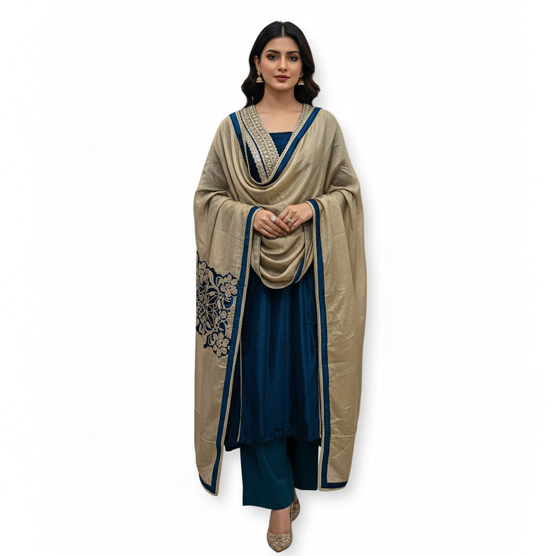 This rich outfit is perfect for the winter season. It is made from soft and warm velvet fabric in a lovely deep teal blue color.

The long kurta has beautiful shiny mirror work and golden patterns on the neckline and sleeves to give it a festive look.

It comes with a contrasting golden dupatta that drapes nicely. This outfit is cozy, elegant, and great for winter weddings and parties.
