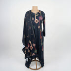 This stylish outfit is in a dark navy blue color. The kurta features unique geometric patterns (like diamonds and shapes) in pink, green, and beige that give it a modern look. It has a simple, comfortable neckline. It comes with matching pants and a warm shawl (dupatta) with the same cool design. This outfit is trendy, cozy, and perfect for casual outings and winter days.