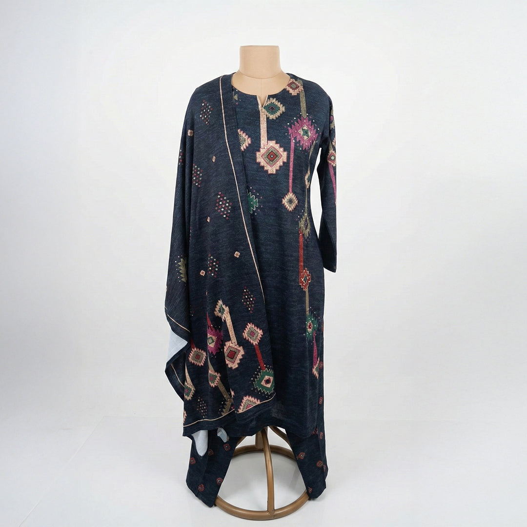 This stylish outfit is in a dark navy blue color. The kurta features unique geometric patterns (like diamonds and shapes) in pink, green, and beige that give it a modern look. It has a simple, comfortable neckline. It comes with matching pants and a warm shawl (dupatta) with the same cool design. This outfit is trendy, cozy, and perfect for casual outings and winter days.
