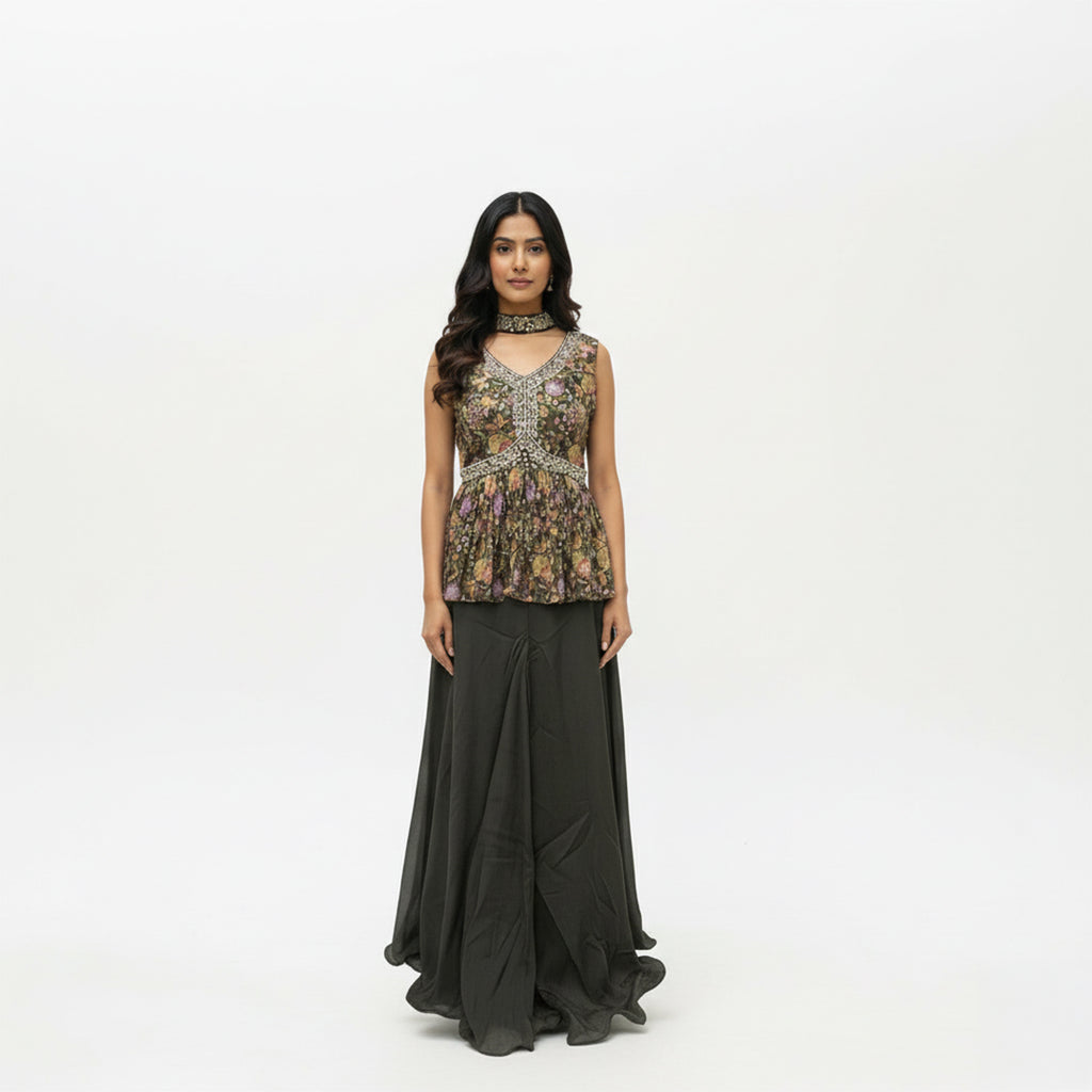 This stylish outfit features a short frock-style top with a beautiful floral print and detailed embroidery on the V-neckline. It is paired with a solid, dark-colored palazzo that is smooth and flowy. The set includes a matching dupatta, making it a trendy and elegant choice for parties.