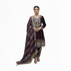 Exude royalty in this Deep Purple Micro-Velvet Kurta Set, a perfect choice for winter weddings. The rich velvet bodice is heavily embellished with authentic mirror work and Gota Patti embroidery, accented by elegant pearl-bead droplets. Paired with a contemporary multi-tonal striped dupatta, this ensemble seamlessly blends traditional opulence with modern styling for a truly elegand festive look