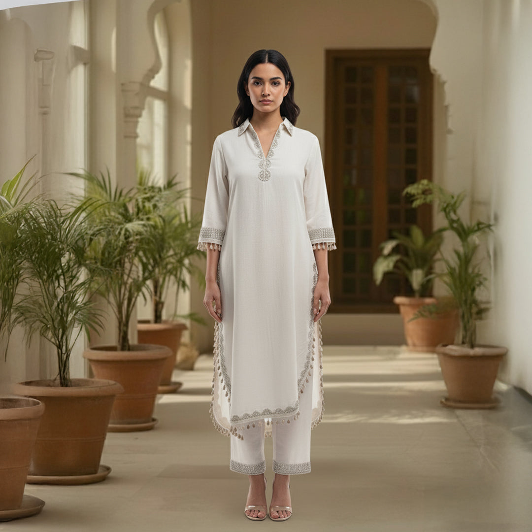 This simple and elegant outfit in a soft off-white color with delicate silver embroidery. The neckline, sleeves and borders are beautifully detailed with fine threadwork and tiny tassels that add a charming touch.

The straight cut and light fabric give it a graceful and comfortable look, perfect for both casual and semi-formal occasions.


Minimal yet classy, this outfit is ideal for daytime gatherings, festive lunches or when you want to look effortlessly stylish.