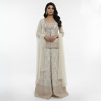 This graceful outfit is designed in a soft ivory shade with delicate golden embroidery that gives it a refined, elegant look. The fitted jacket style top has a beautiful neckline and fine handwork along the edges adding a hint of sparkle.

The wide-leg pants feature matching floral embroidery with a rich border creating a balanced and stylish appearance.


A light, sheer dupatta with tiny embroidered dots completes the outfit making it perfect for weddings, festive occasions or any event where you want to l