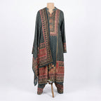 This traditional outfit is in a smart dark grey color. The kurta features a unique wavy line pattern all over and a detailed design on the neck in red and beige colors. It comes with matching pants and a beautiful shawl (dupatta) that has a rich, printed border. This outfit is elegant, comfortable, and perfect for office wear or casual winter days.
