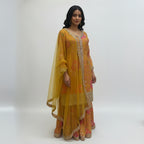 This vibrant outfit features a warm mustard base with beautiful pink floral prints and golden embroidery that give it a festive and cheerful look. The neckline and sleeves are decorated with fine handwork, adding a touch of sparkle and detail.

The flared palazzo pants carry the same floral design and embroidered borders, creating a perfect match with the top.

A soft yellow dupatta with mirror work and a fancy border completes the outfit. Bright and elegant, this ensemble is ideal for mehndi, haldi or any 