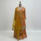 This vibrant outfit features a warm mustard base with beautiful pink floral prints and golden embroidery that give it a festive and cheerful look. The neckline and sleeves are decorated with fine handwork, adding a touch of sparkle and detail.

The flared palazzo pants carry the same floral design and embroidered borders, creating a perfect match with the top.

A soft yellow dupatta with mirror work and a fancy border completes the outfit. Bright and elegant, this ensemble is ideal for mehndi, haldi or any 
