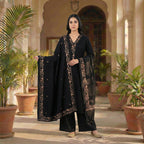 This classic outfit is in a deep black color. It is made from soft velvet fabric which is perfect for winter. The kurta has beautiful golden flower embroidery on the neckline, sleeves, and bottom hem. It comes with matching pants and a lovely shawl (dupatta) with a matching embroidered border. This outfit is simple, elegant, and great for evening parties and winter dinners.