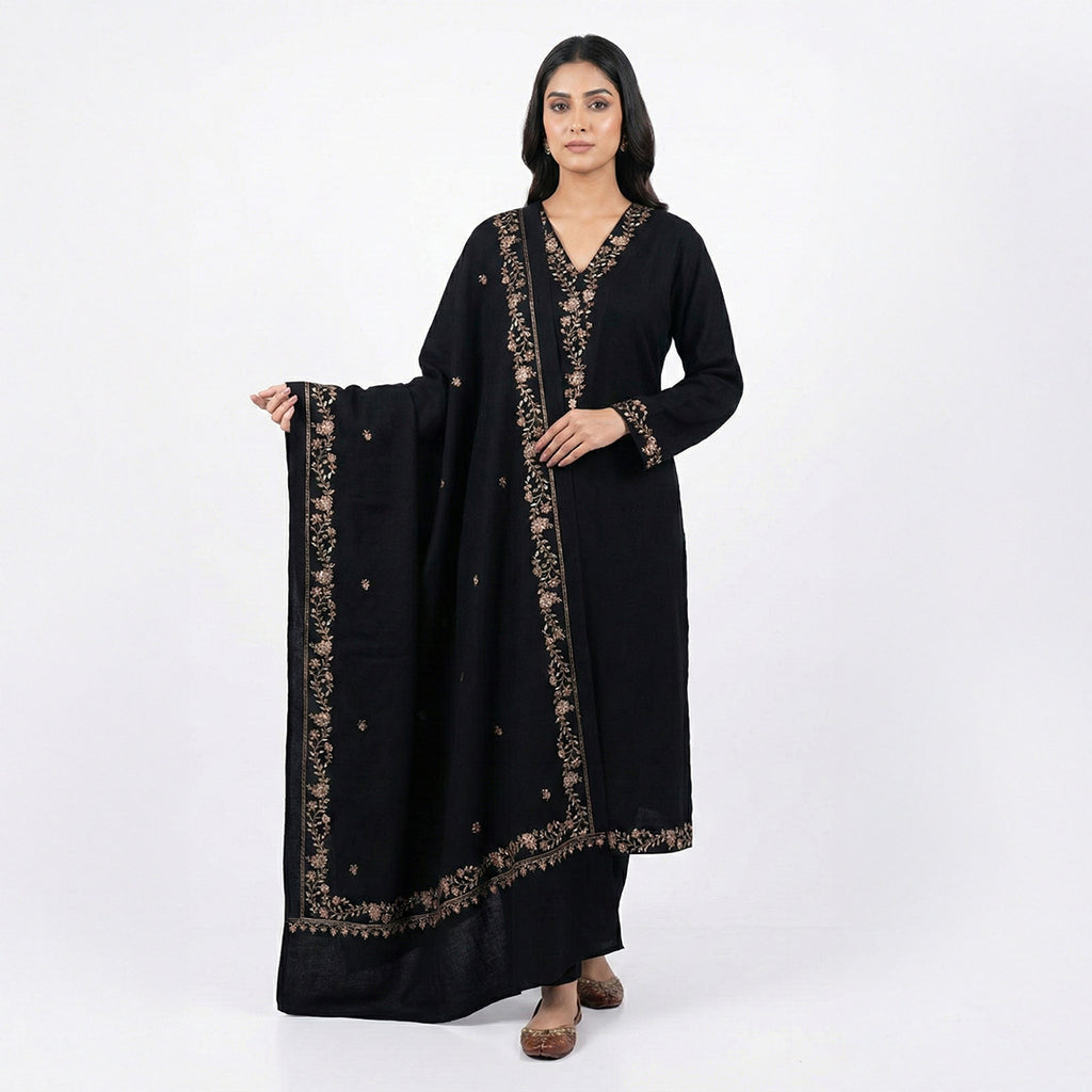 This classic outfit is in a deep black color. It is made from soft velvet fabric which is perfect for winter. The kurta has beautiful golden flower embroidery on the neckline, sleeves, and bottom hem. It comes with matching pants and a lovely shawl (dupatta) with a matching embroidered border. This outfit is simple, elegant, and great for evening parties and winter dinners.