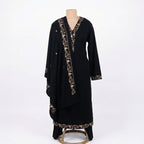 This classic outfit is in a deep black color. It is made from soft velvet fabric which is perfect for winter. The kurta has beautiful golden flower embroidery on the neckline, sleeves, and bottom hem. It comes with matching pants and a lovely shawl (dupatta) with a matching embroidered border. This outfit is simple, elegant, and great for evening parties and winter dinners.